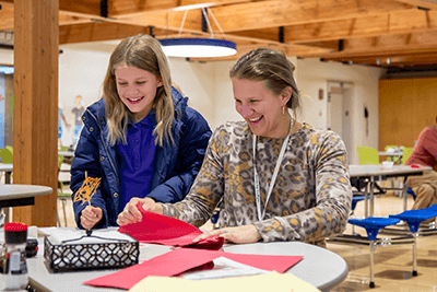 A parent and daughter laughing.