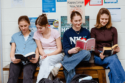 Four students reading books. 