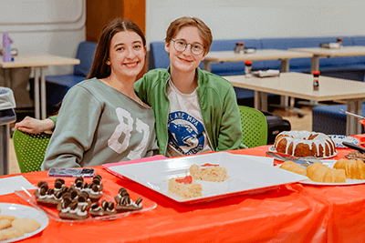 Two MPA Upper School students selling pastries. 