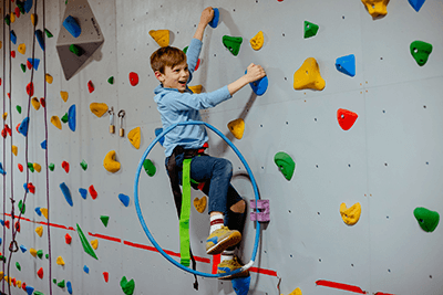 A student on a rock climbing wall