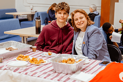 A parent and child at a table smiling