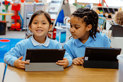 Two students working on iPads. 