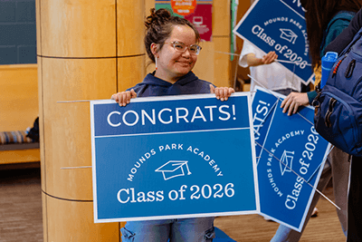 A member of the Class of 2026 poses with a sign. 