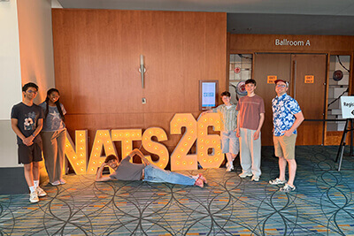 Speech students posing in front of 2026 Nationals sign.